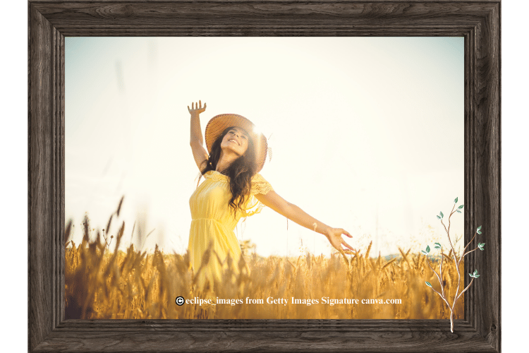 Woman dancing in field and sunshine appearing happy and celebatory.